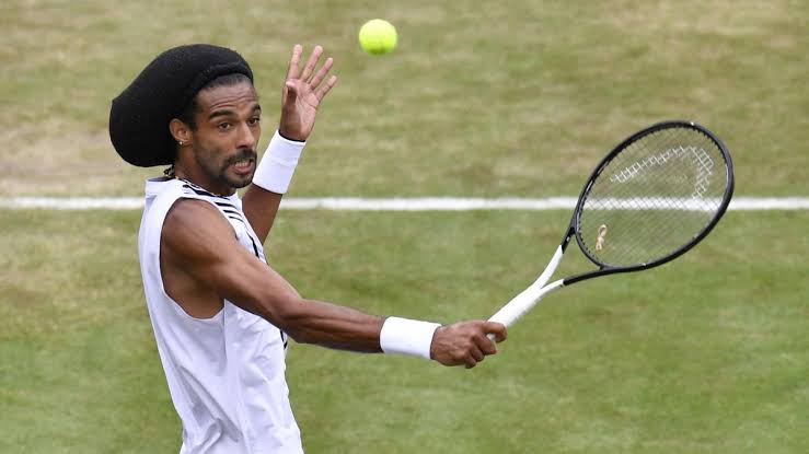Dustin Brown con gorro de lana jugando al tenis.