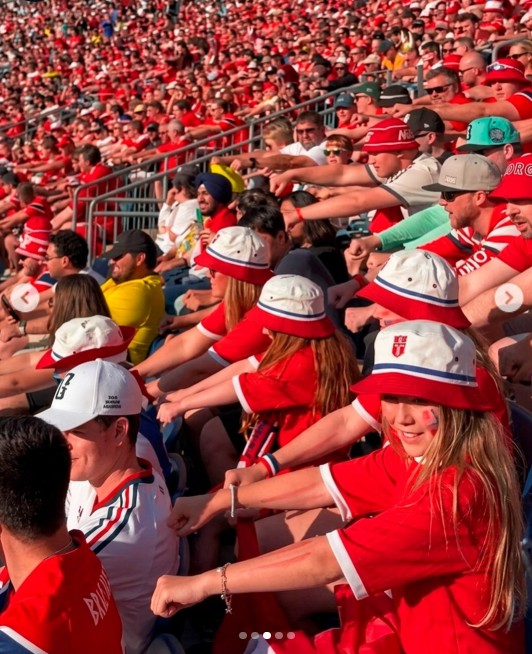 Los aficionados noruegos en las tribunas simulan remar en una embarcación vikinga